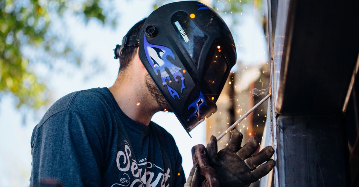 Mobile welder working outdoors with sparks coming off the weld